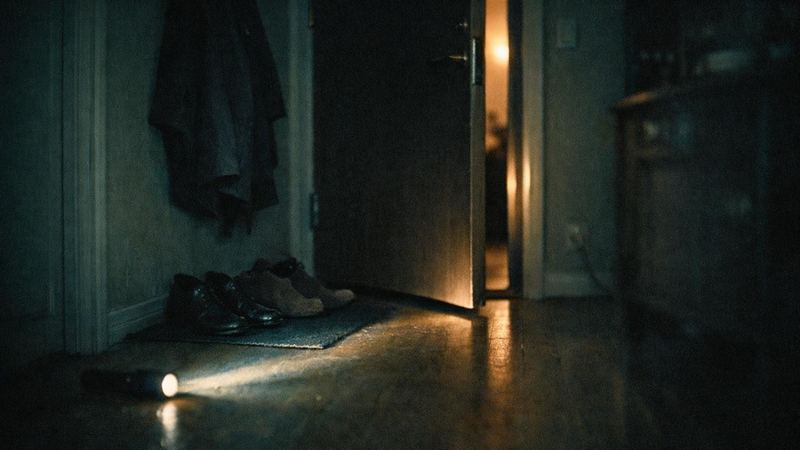 Hall i en lägenhet nattetid med ljus från en ficklampa